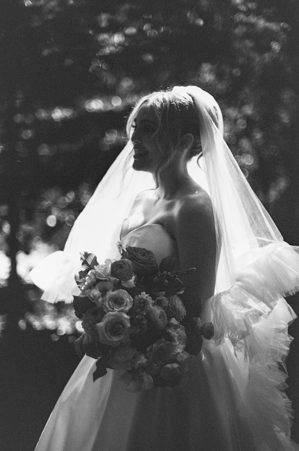 A dreamy black and white wedding portrait series showing romantic moments with flowing veils and floral bouquets.