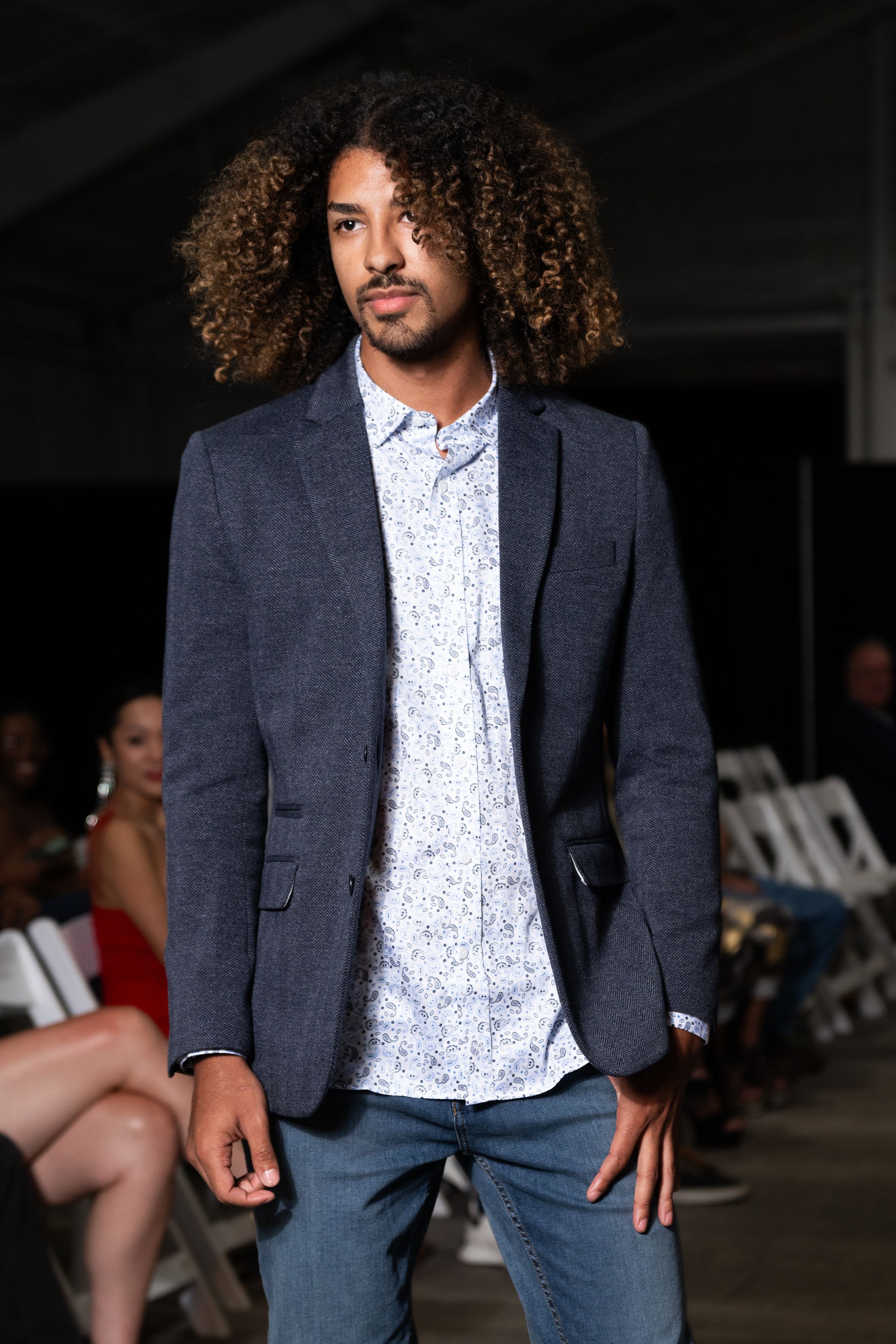 Professional fashion model wearing navy blazer and polka dot shirt poses in multiple stylish shots.