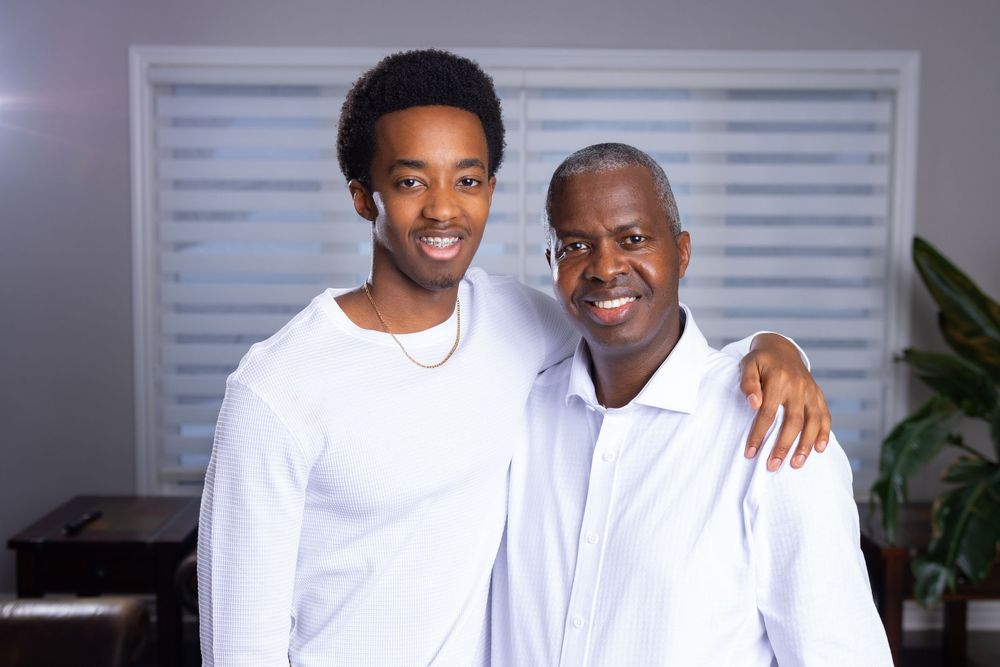 A group photo showing people in coordinated white shirts and jeans standing together in a home setting.