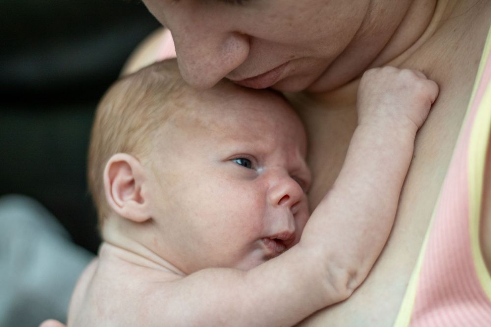 Mother holding newborn close to chest.