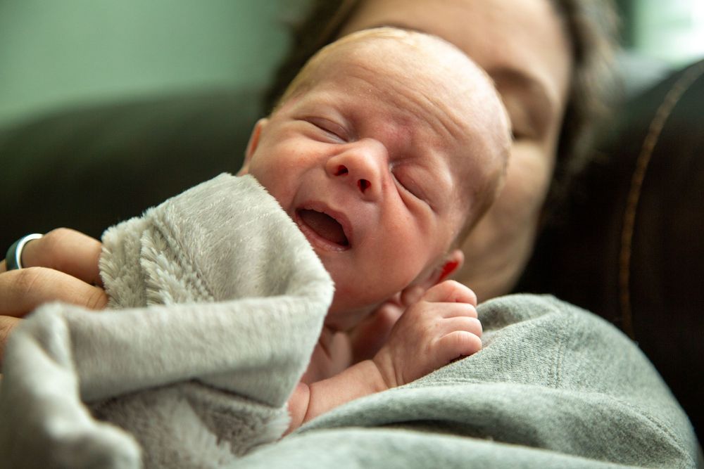 Mother holding smiling newborn.