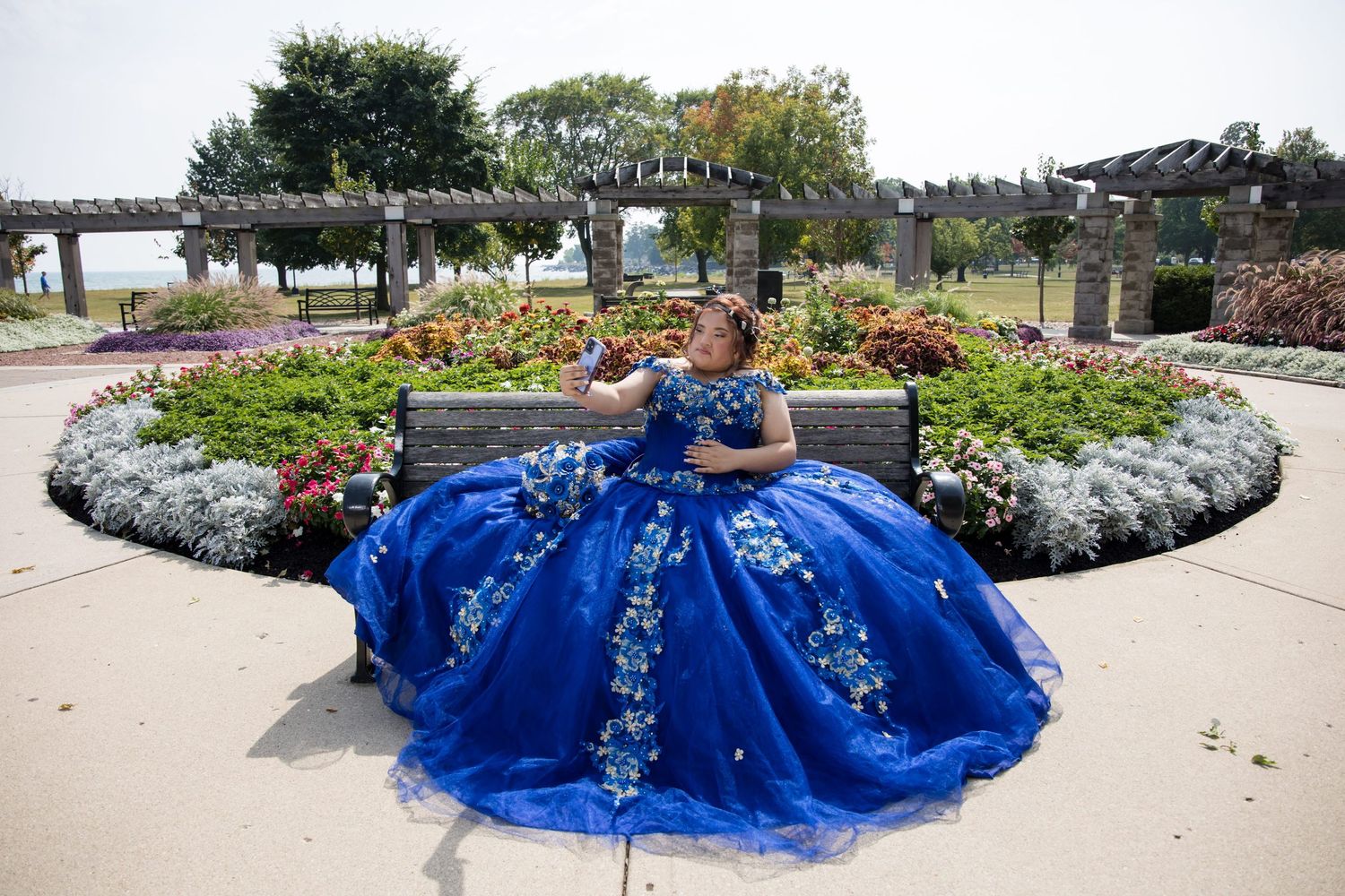 Quinceañera sitting in a floral garden at Independence Grove. Breathtaking royal blue XV gown portraits by Alex T Photography Lake County.