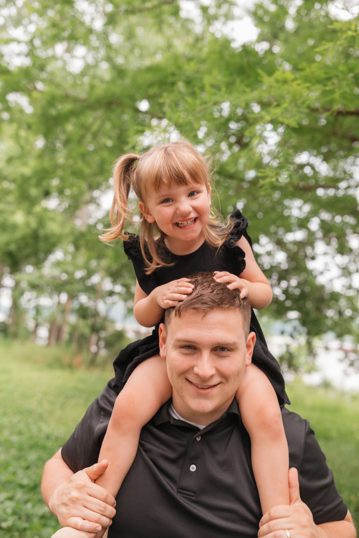 A playful piggyback ride moment captured in a green outdoor setting.