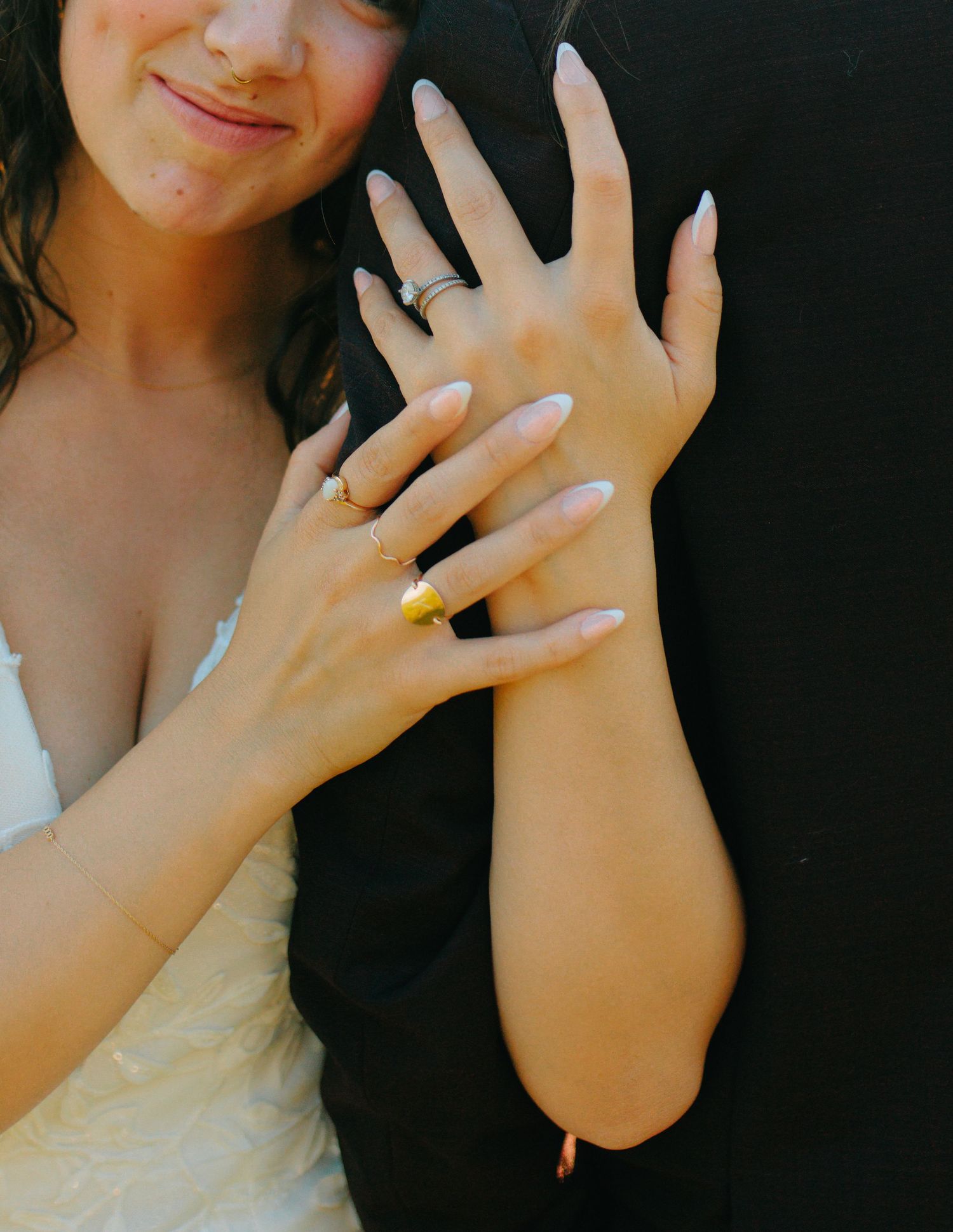 Detail shots of hands with wedding rings against a dark background.
