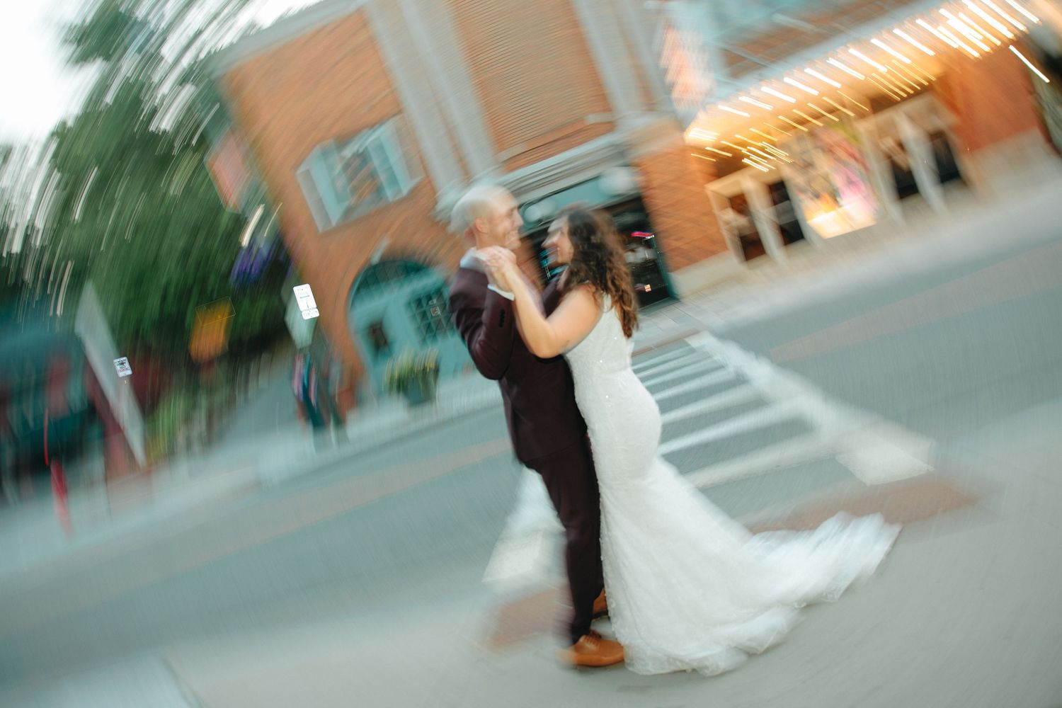 A blurred motion sequence of a couple dancing together on a tiled floor with warm lighting in the background.