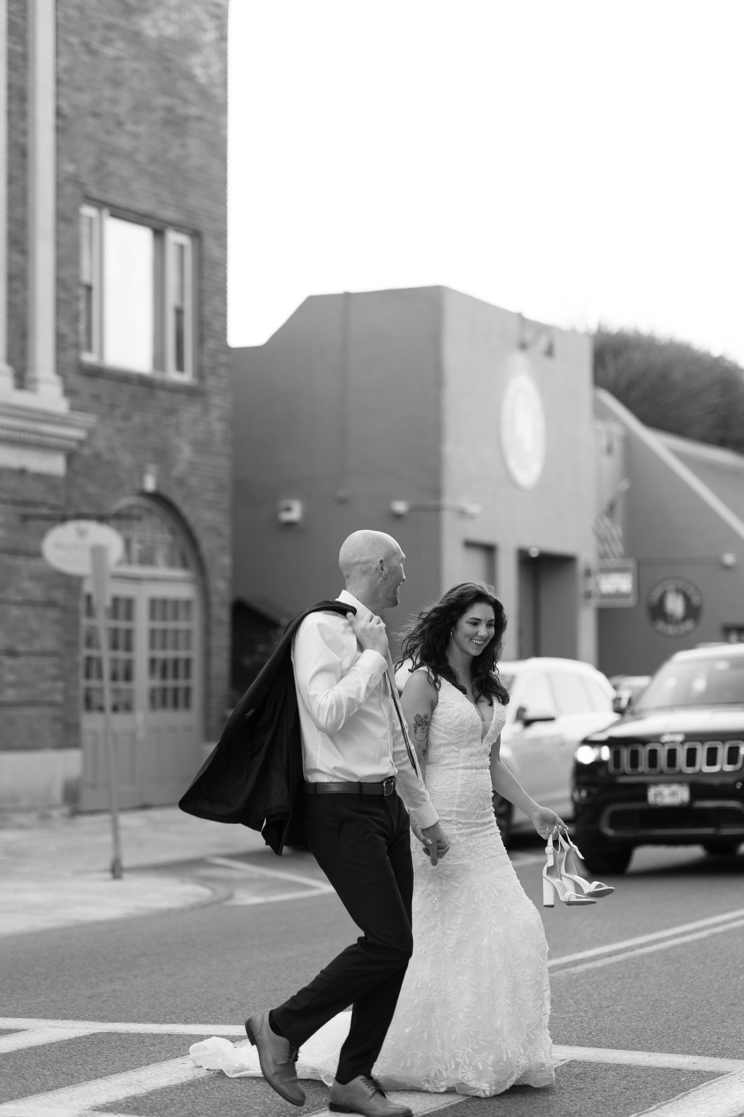 Black and white sequence of newlyweds playfully dancing in a parking lot.