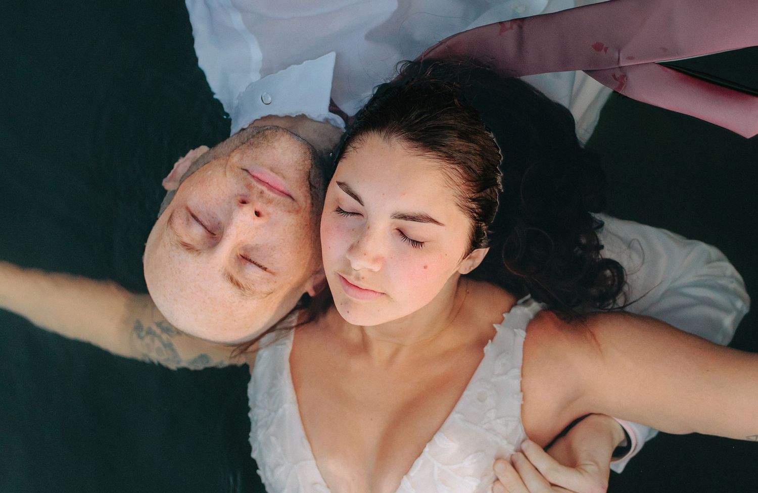 Overhead view of couple lying down together after their wedding celebration.