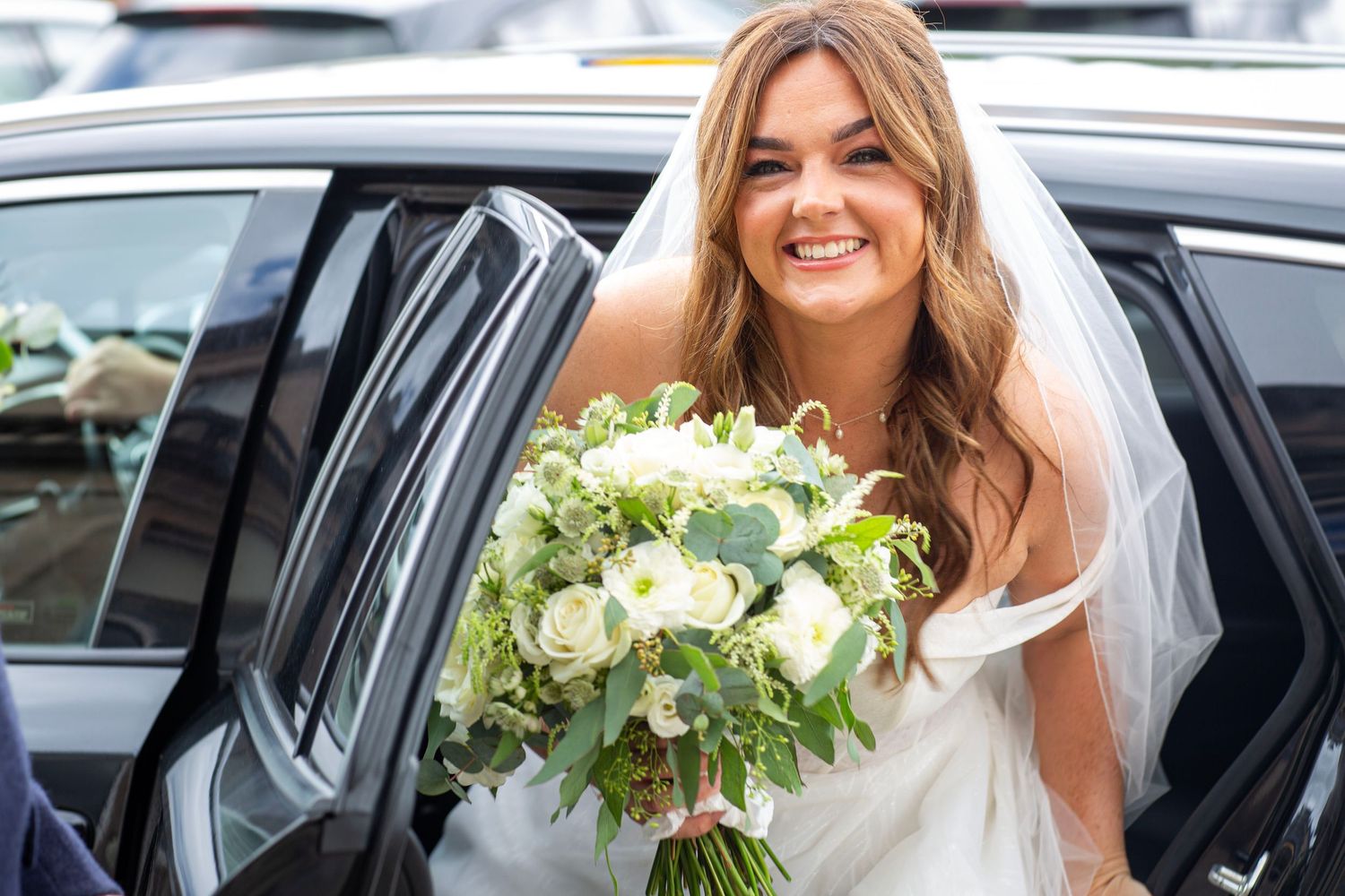 bride coming out of the car and heading to church