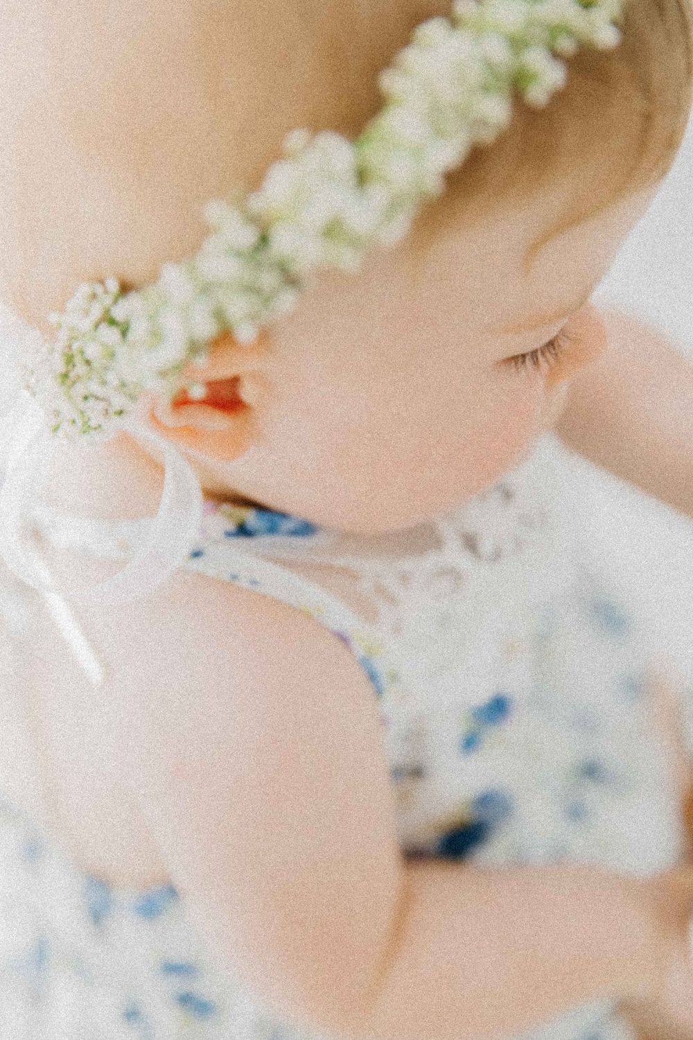 Close-up profile of baby wearing delicate flower crown. Fotografia de maternidade, recém-nascido e família em Alenquer, Lisboa e Portugal.