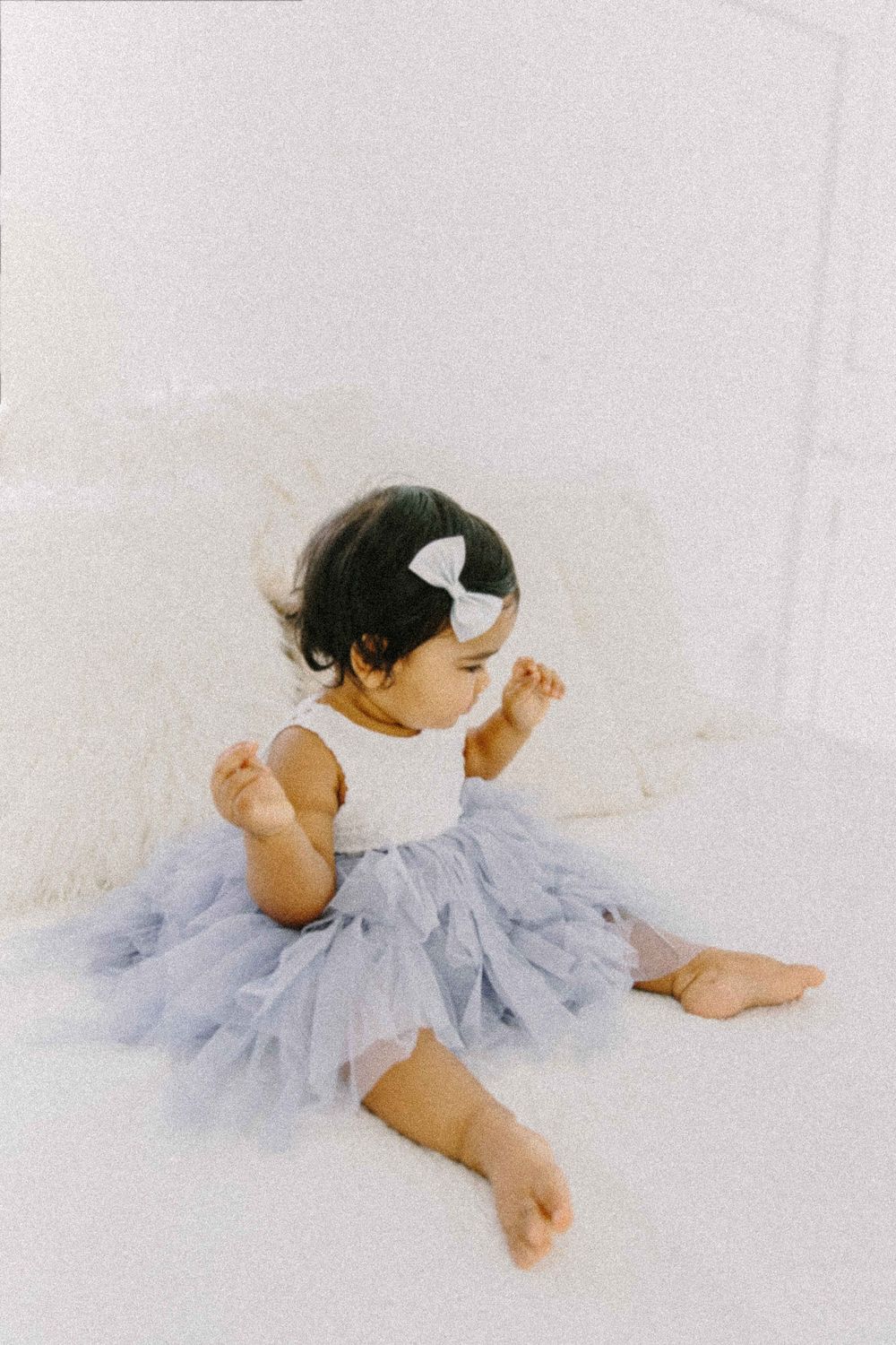 Baby in purple tutu dress sits on white background Fotografia de maternidade, recém-nascido e família em Alenquer, Lisboa e Portugal.