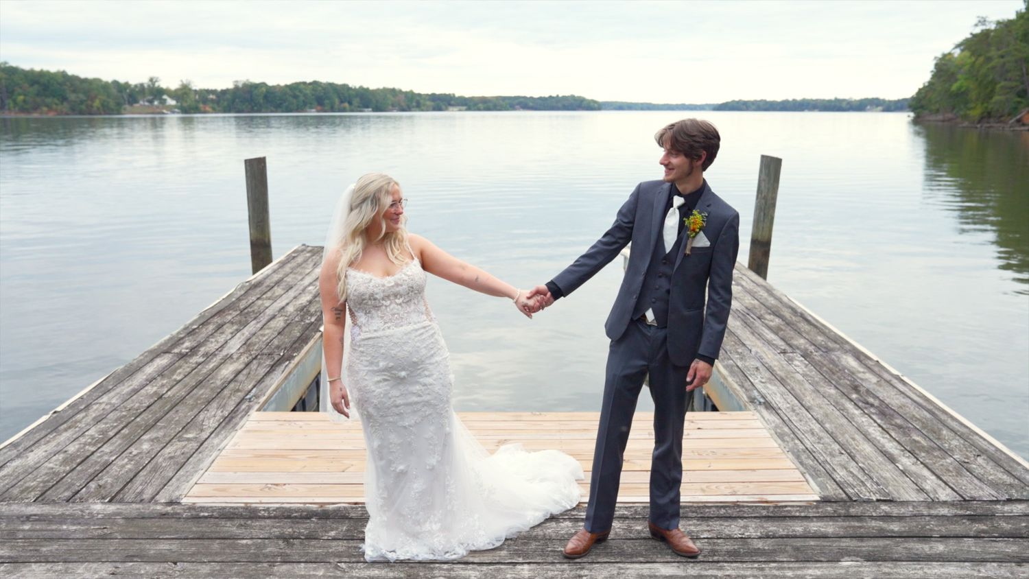 A couple in wedding attire walking on a garden path, sharing a joyful moment together on their special day.