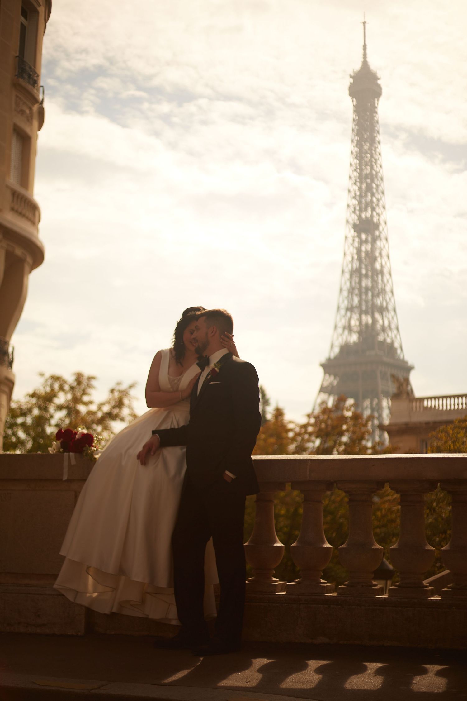 Romantic silhouettes against Paris skyline with Eiffel Tower at sunset.