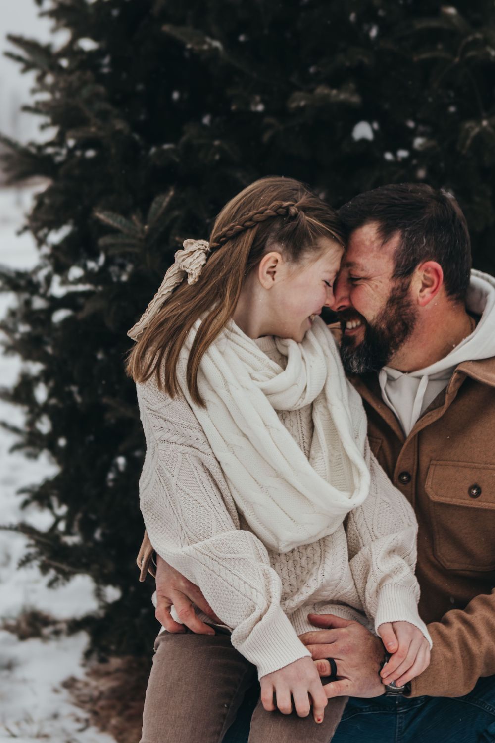 Father and daughter share adorable moment in the snow.
