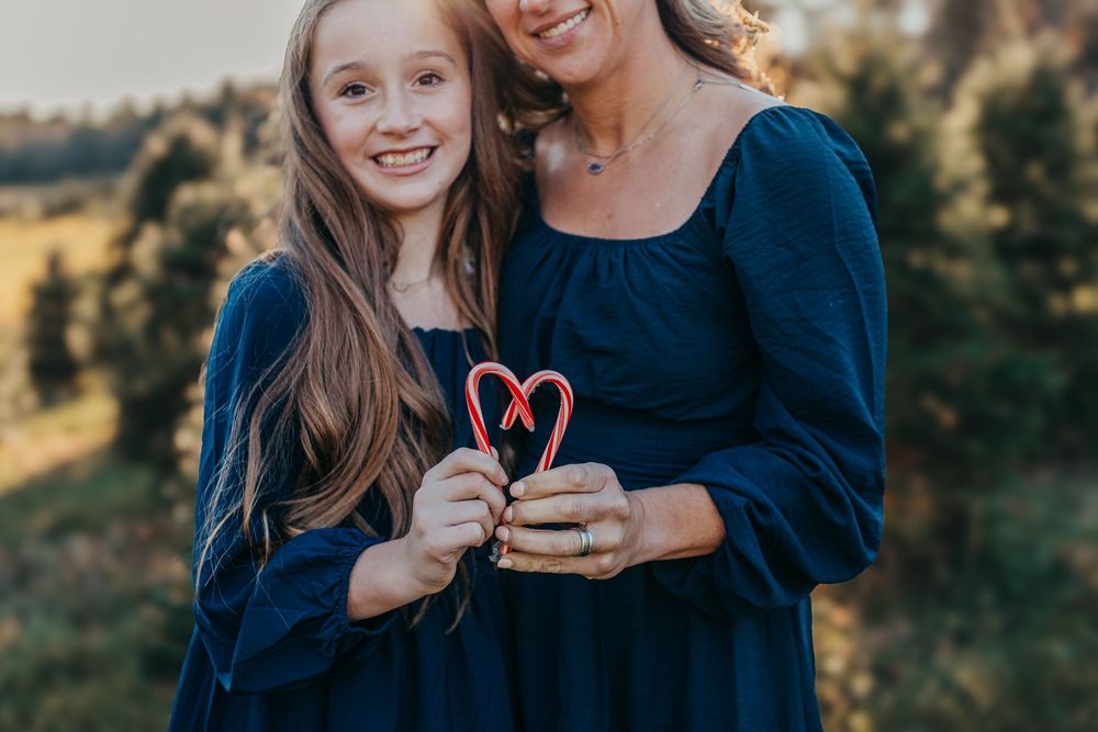 Mom and daughter share a cute photo with a candycane during their session.