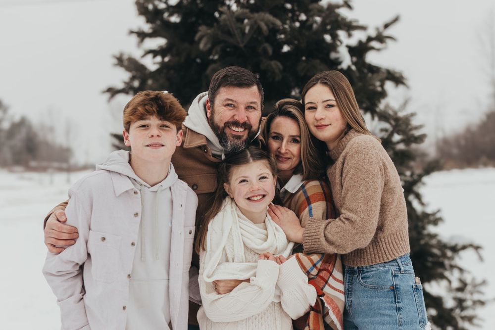 A candid family photo session in the snow with everyone dressed in winter layers.