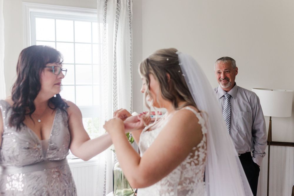 A sequence of candid wedding day moments showing heartfelt interactions between members of a bridal party next to large windows.
