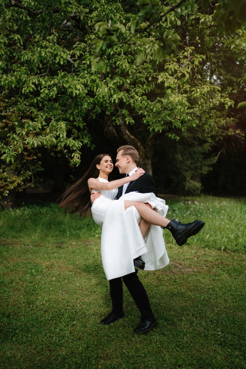 A romantic moment captured in a lush garden setting with flowing white dress.