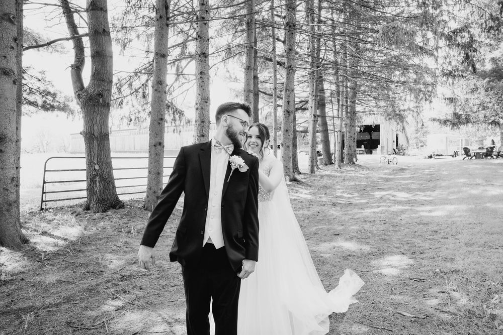 Black and white photo series of joyful newlyweds celebrating their special day in a serene outdoor forest setting.