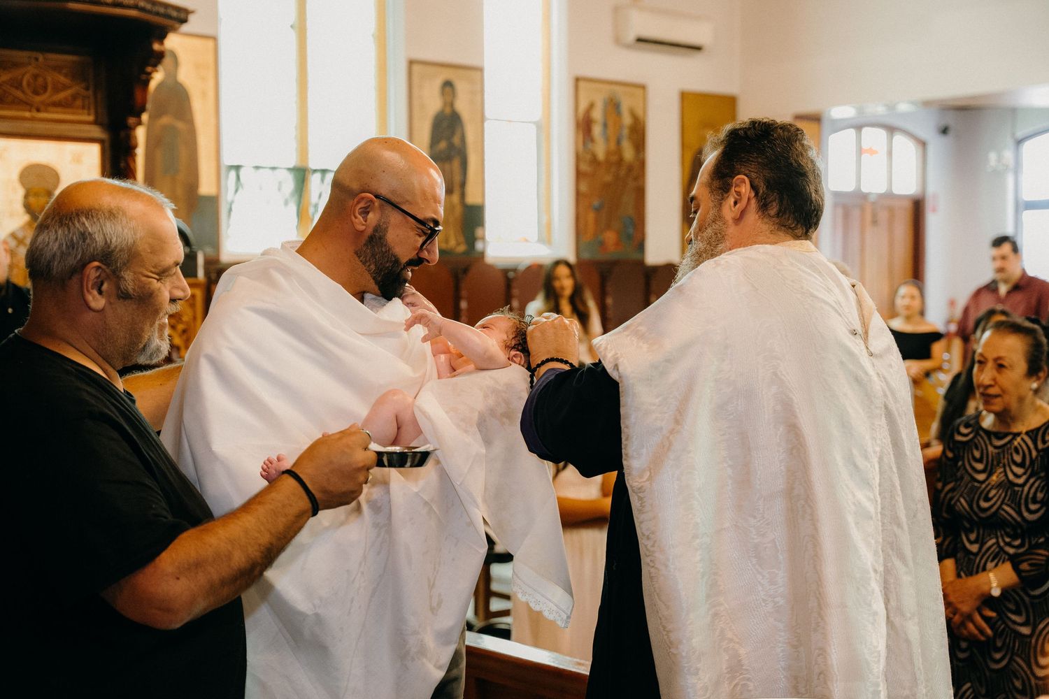 Wine tasting attendees sample different varietals while standing at a white-clothed table in a bright indoor space.