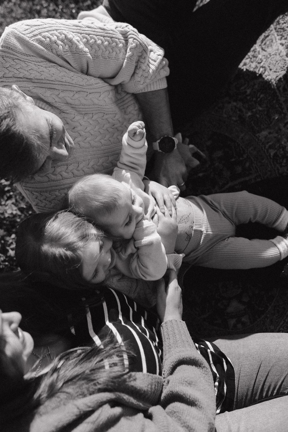A close sequence of candid black and white photos showing people reclining and relaxing together outdoors.