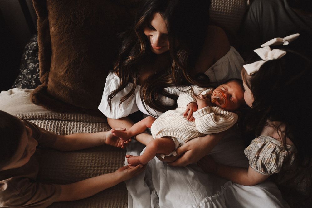Moody sequence of nurturing moments captured in dark, atmospheric lighting.