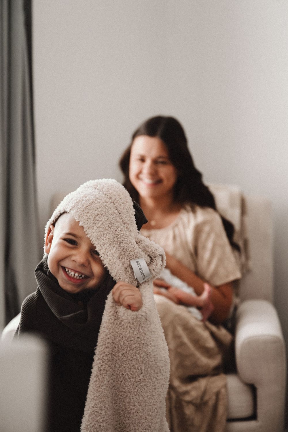 Playful sequence showing joyful interactions with a cozy beige blanket.