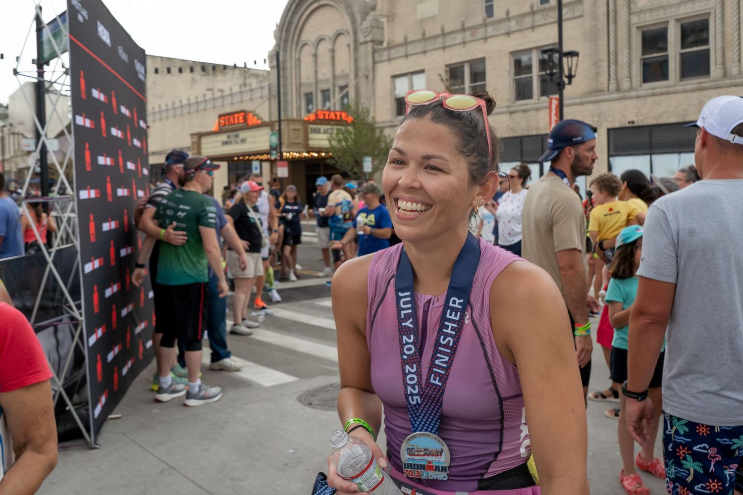 A group of people gathered at an outdoor endurance event wearing purple race bibs and athletic attire.