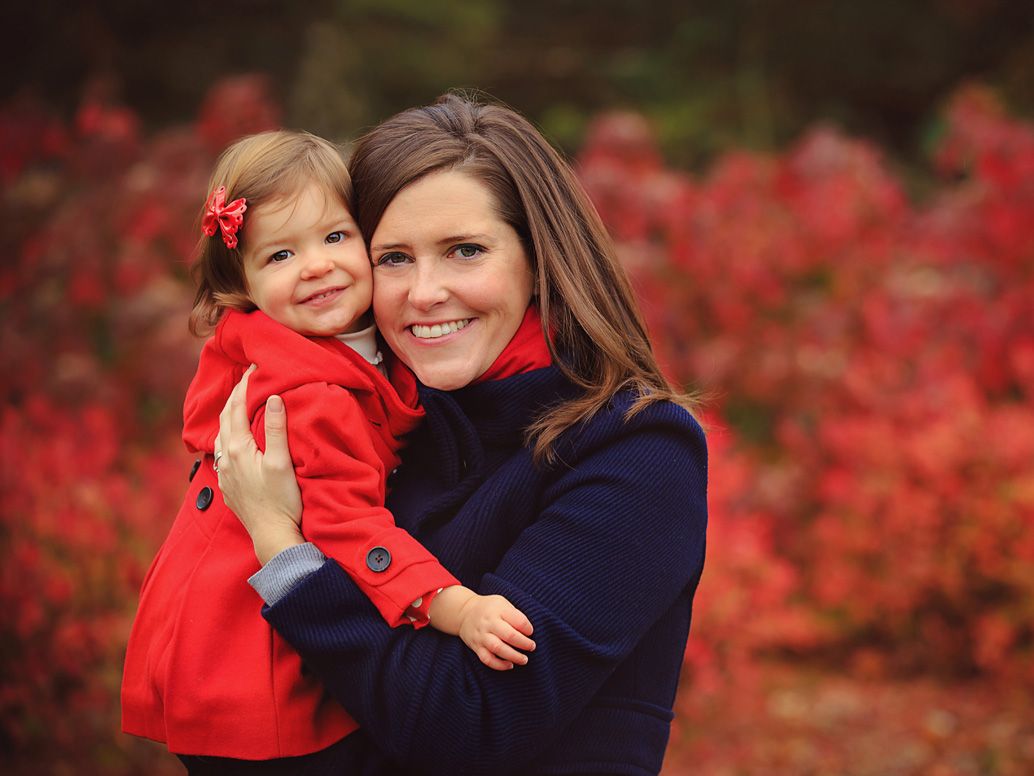 Mother and daughter at park with fall colors, red coat and autumn leaves; family portrait session in Ann Arbor, Michigan.