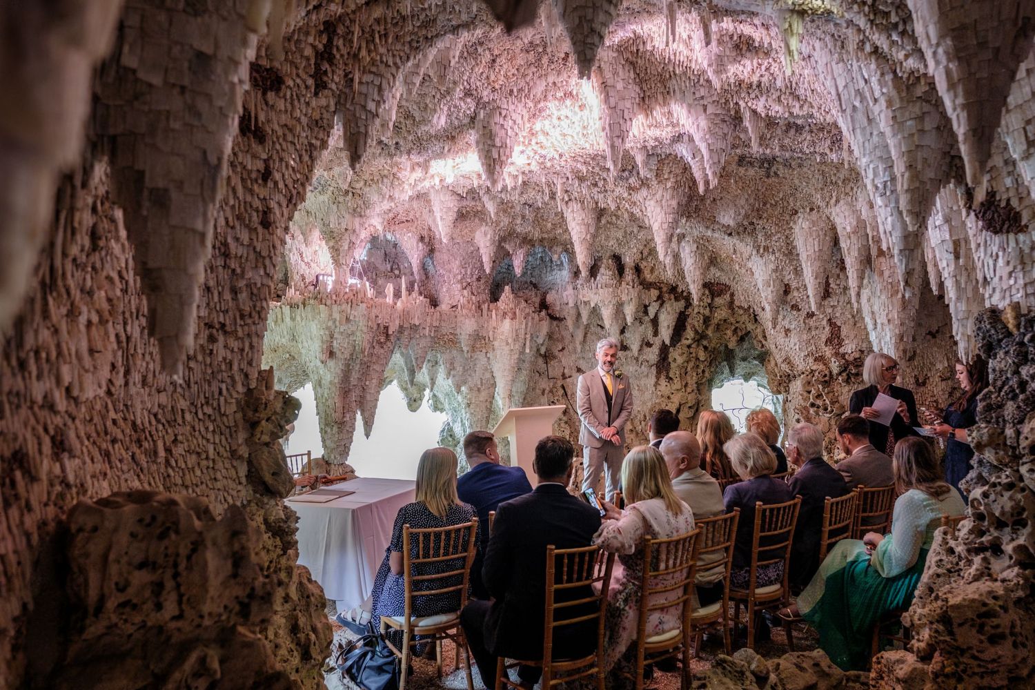 An underground cave restaurant with candlelit tables and stone walls creates a romantic dining atmosphere.