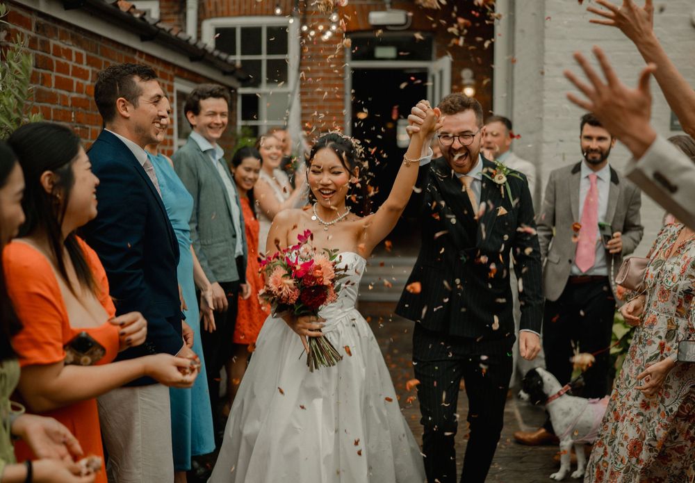 'norfolk wedding, bride and groom walking down as guest throw confetti'