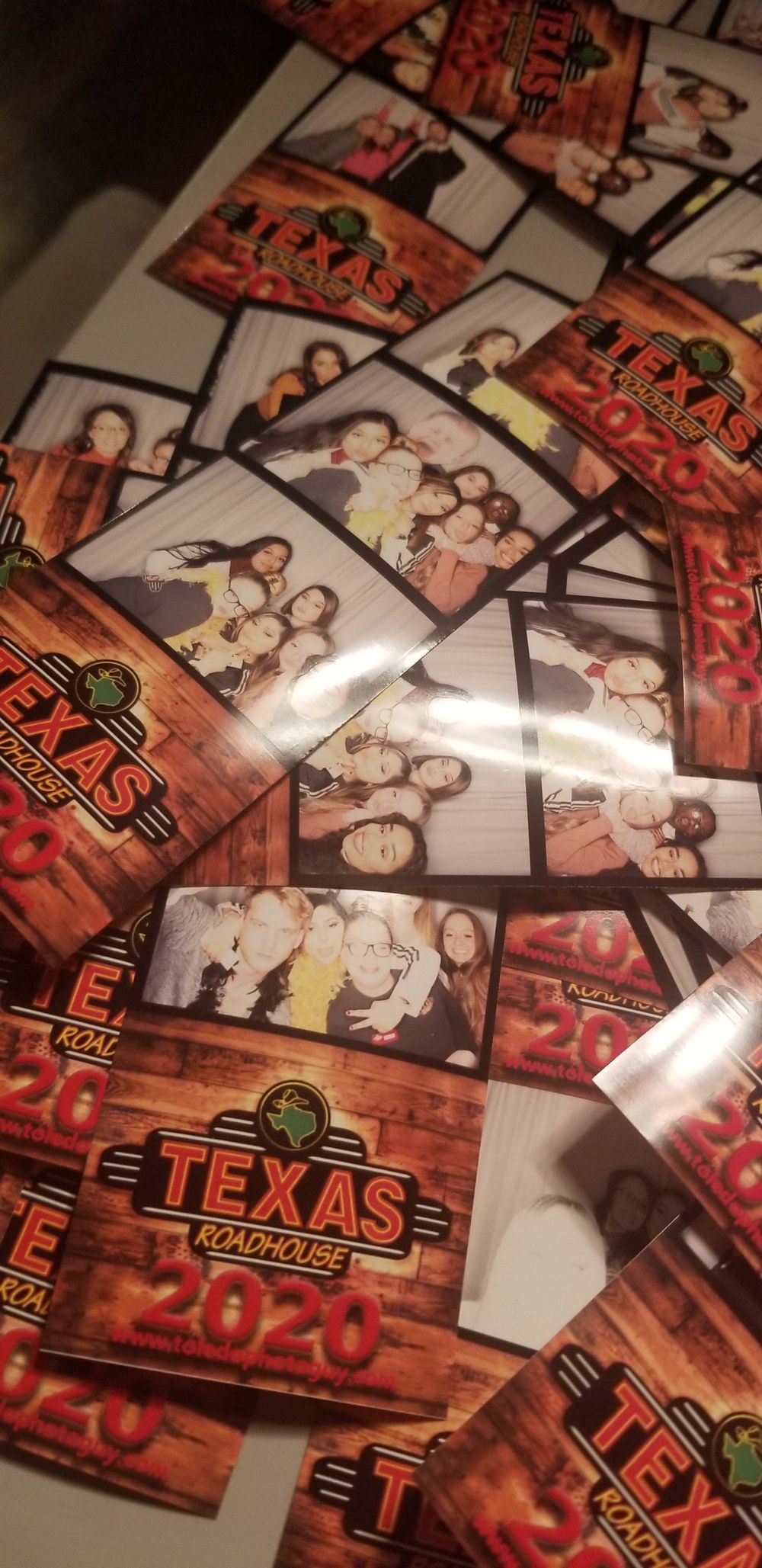 Texas Roadhouse promotional materials and restaurant logos scattered on a wooden surface with red lighting effects.