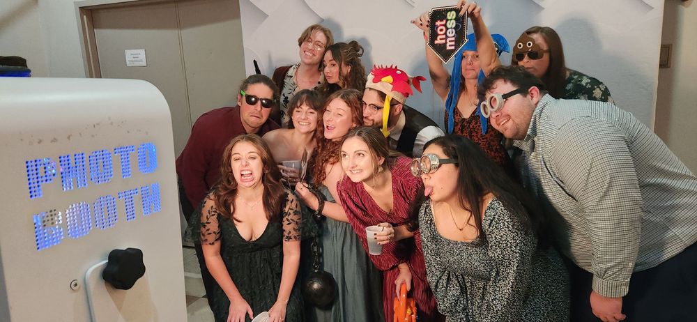 A group of people laughing while huddled together for candid photo booth shots at a social event.