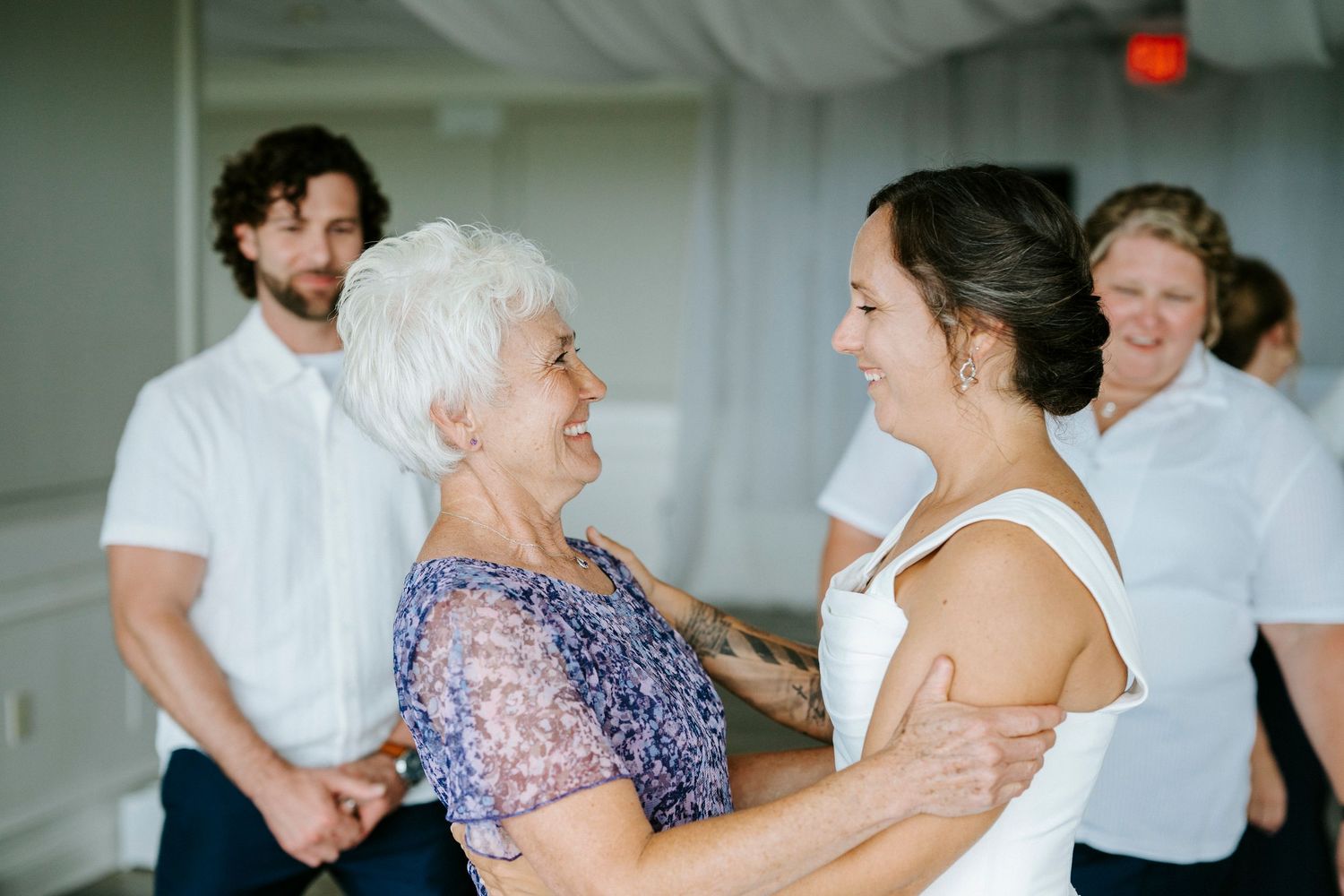 Wedding guests dancing and celebrating at an indoor reception venue.