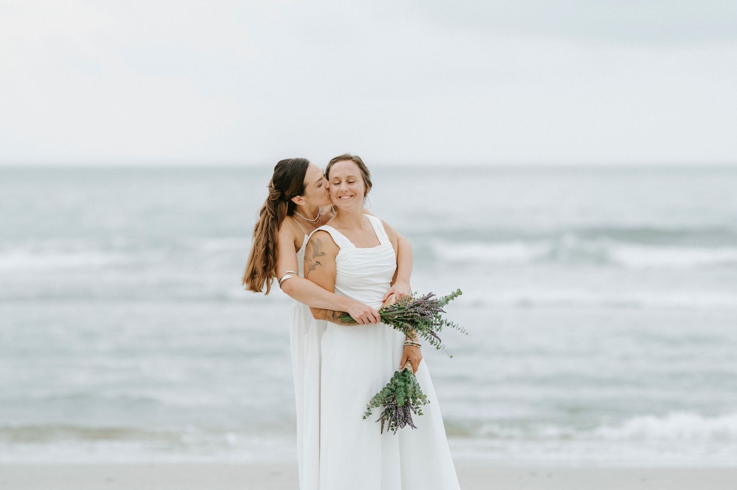 Intimate beachside wedding ceremony with ocean waves in the background.