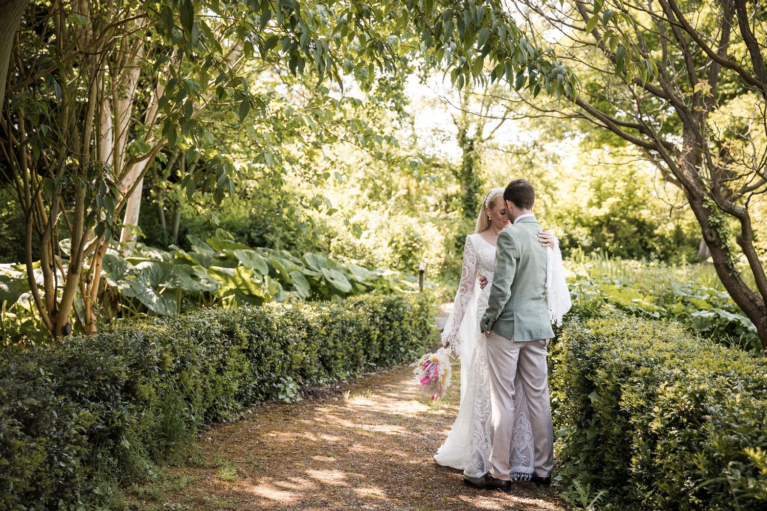 Wedding couple strolling through the gardens of Hodsock Priory