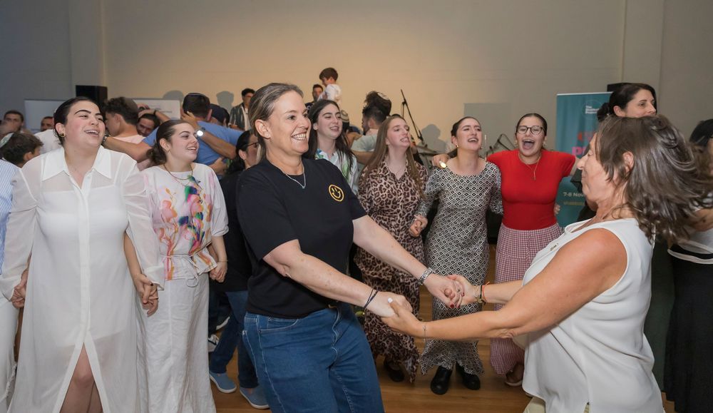 A group of people dancing together in a large indoor space during what appears to be a celebration or party.