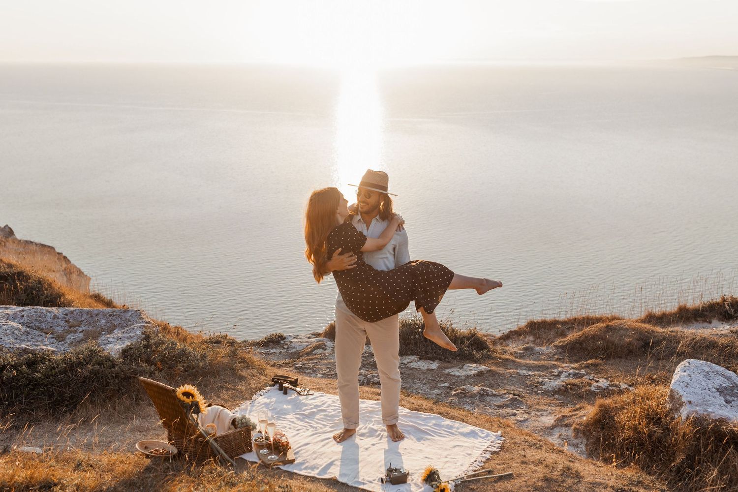 Candid couple portrait of bon amour weddings owners standing on a cliff top in Dorset