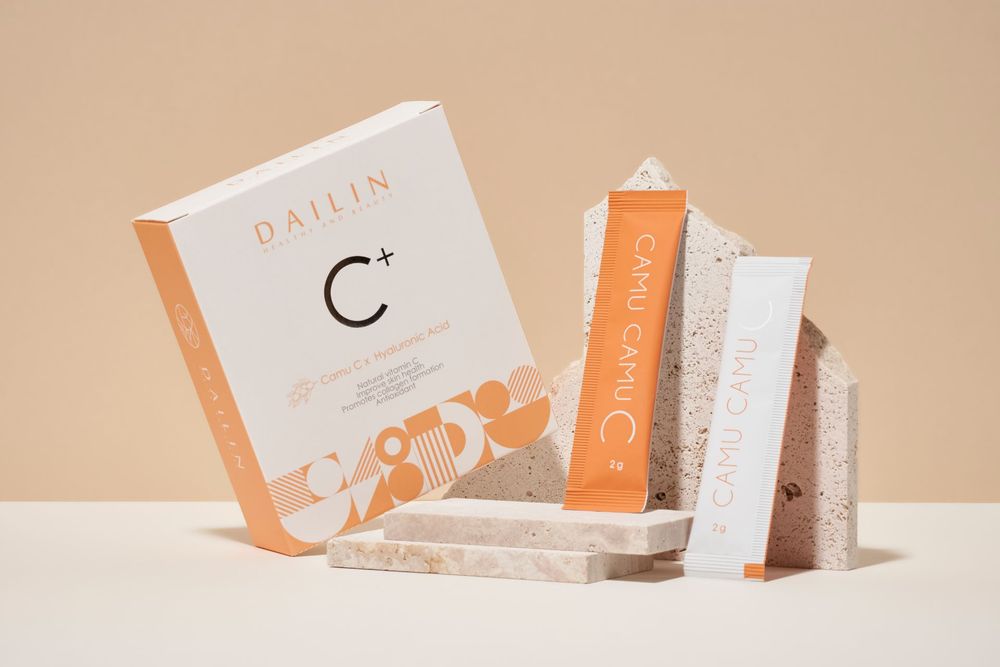 Orange and white product packaging and branding materials arranged on a beige background.