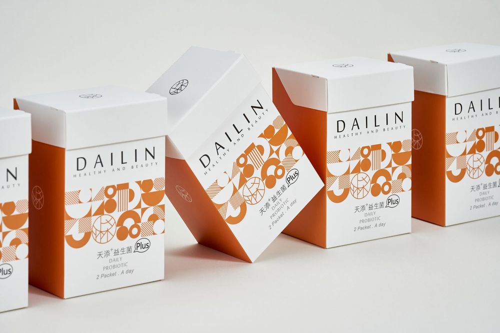 White skincare product boxes with orange floral accents arranged in a minimalist retail display lineup.