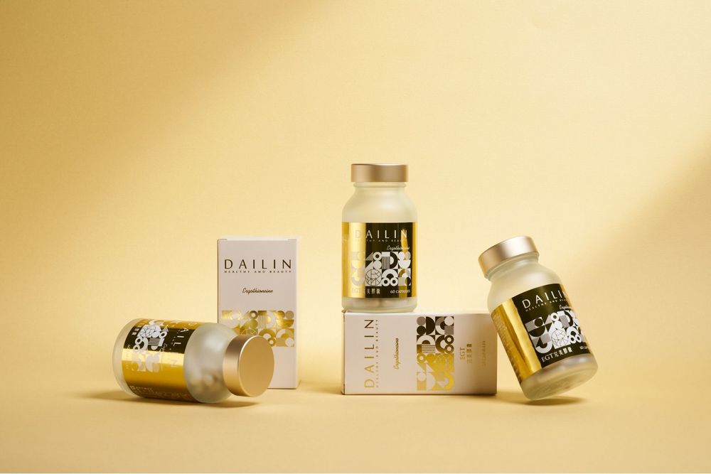 White and gold cosmetic product bottles and containers arranged in a minimalist composition on beige background.