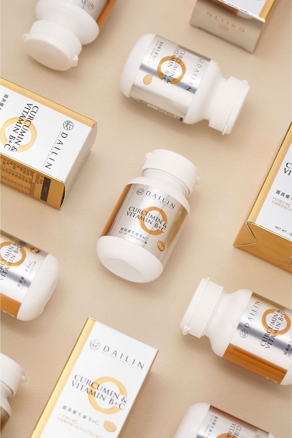 White vitamin supplement bottles with orange accents arranged in a diagonal pattern on beige background.