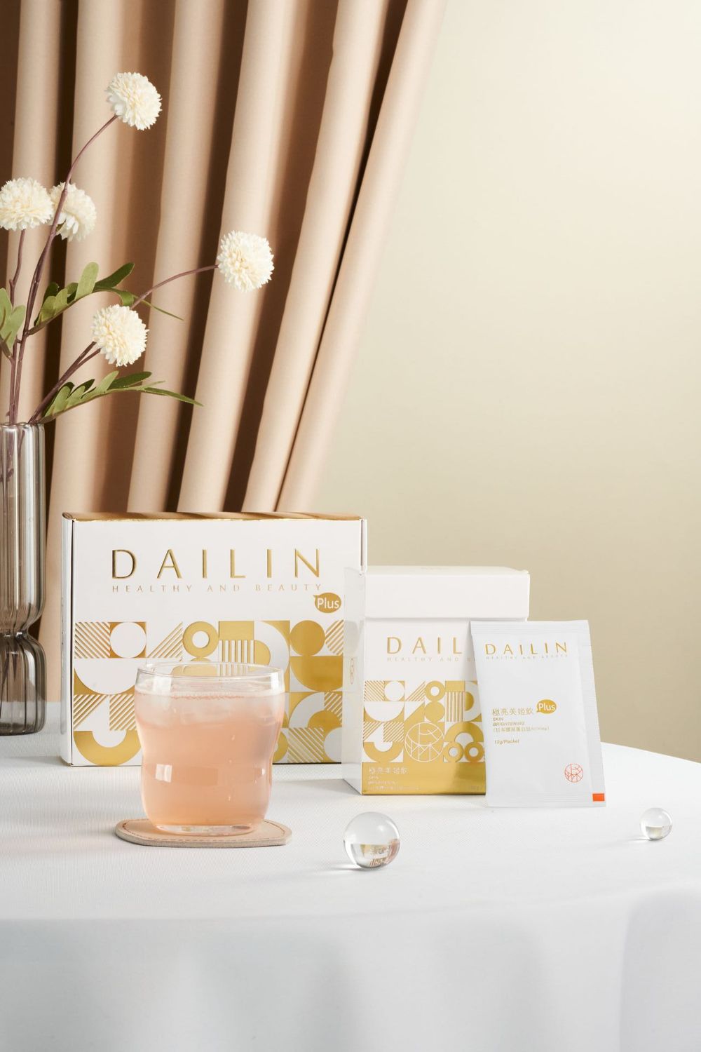 Pink teacup and white flowers displayed alongside Dailin branded packaging on a white tablecloth.