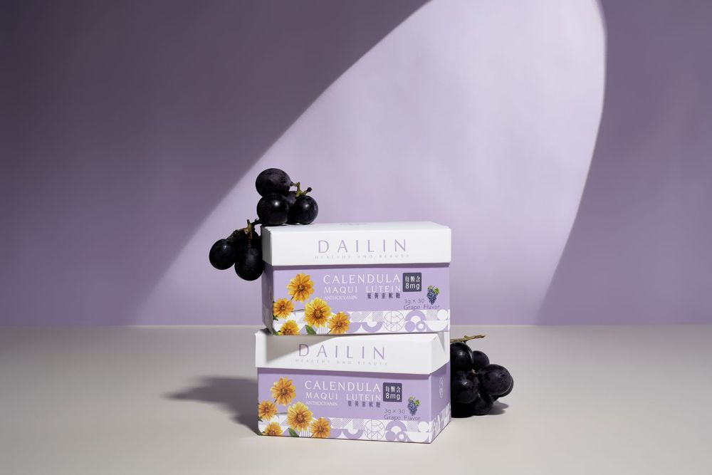 A series of white product boxes with purple accents displayed alongside black and yellow floral decorative elements.