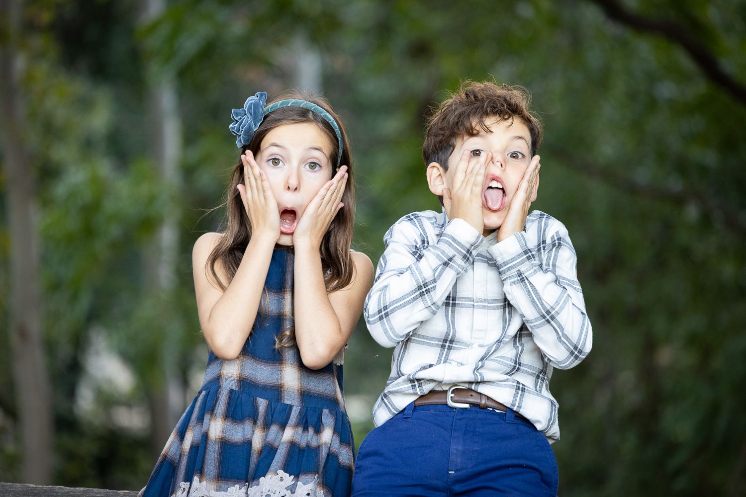 Two children make silly faces for the camera during their family photo session near San Jose, California