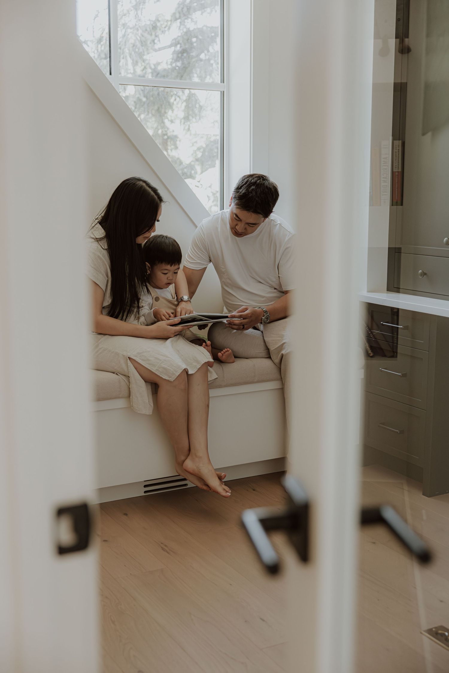 family reading a book together in their home in calgary alberta during a in home family photoshoot