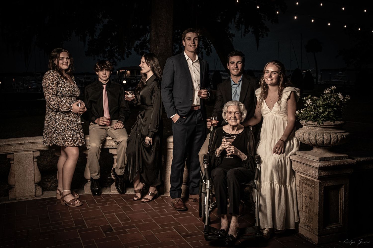 Group of wedding guests gathered on outdoor stone steps at night during an elegant celebration.