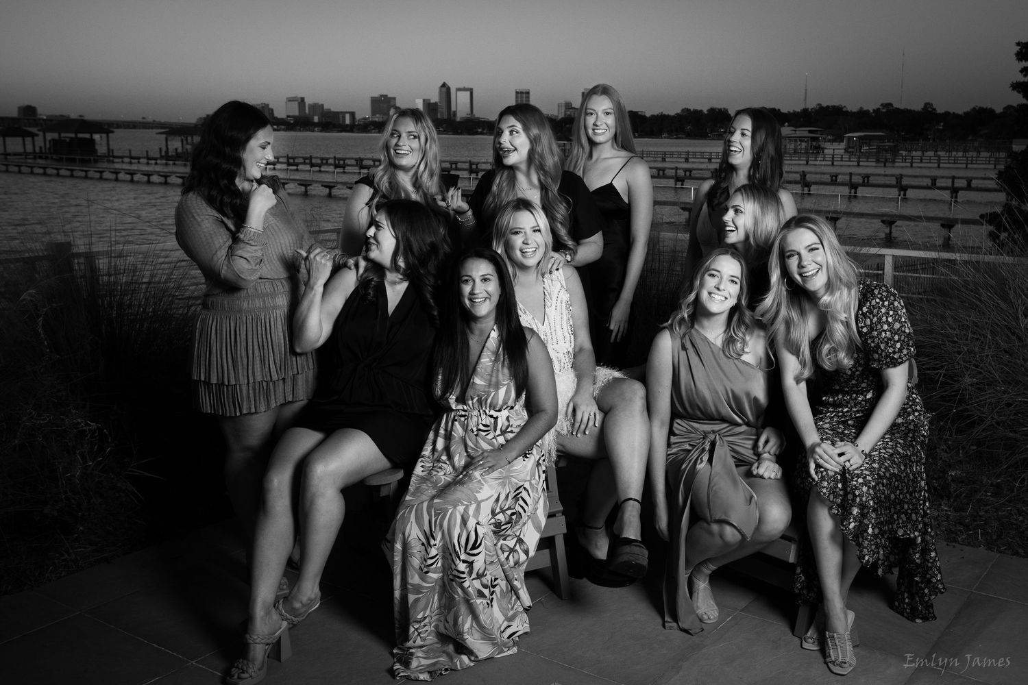 Black and white group portrait of women gathered outdoors at dusk in formal attire for a social gathering.