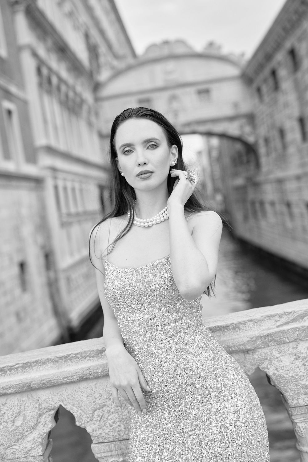 A series of black and white photographs showing a person in a sequined dress posing along Venice's iconic Bridge of Sighs.