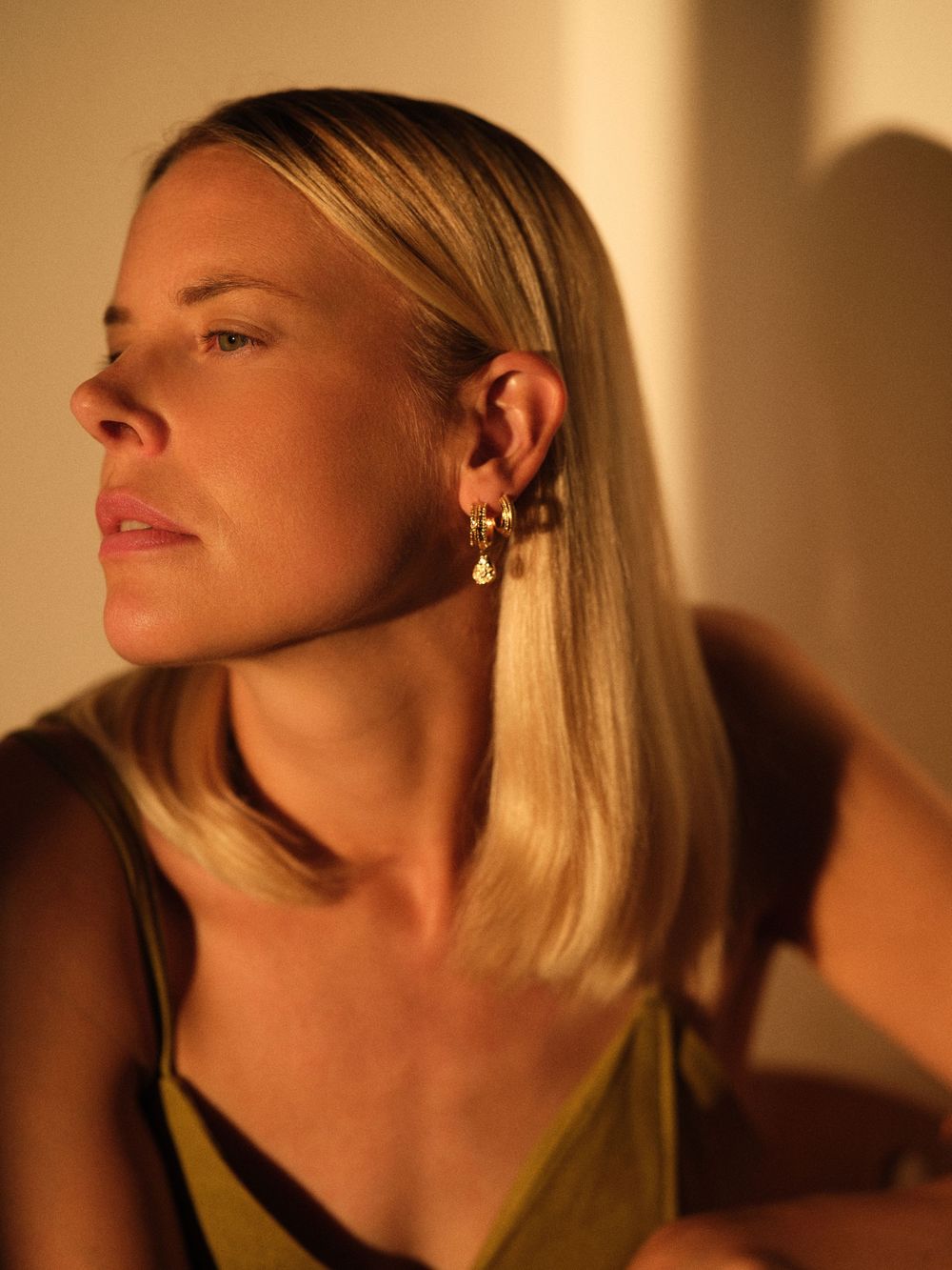 A series of four profile portraits showing a person's face in warm lighting from different angles and expressions.