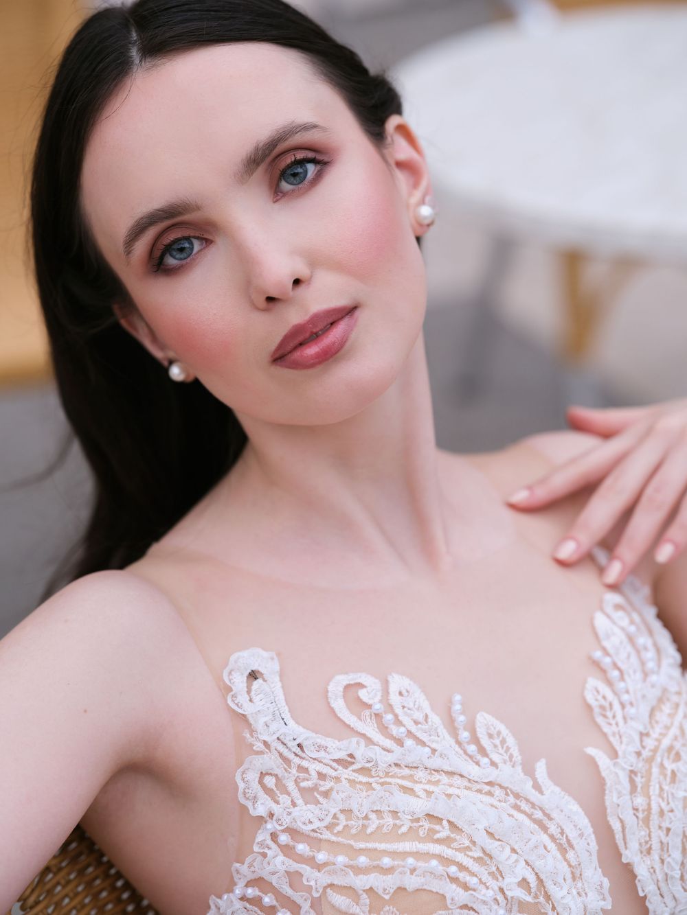 Elegant bridal portrait featuring delicate white lace details and soft romantic makeup in natural lighting.